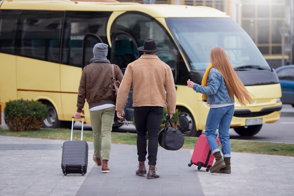 Viajeros con equipaje junto a un bus.